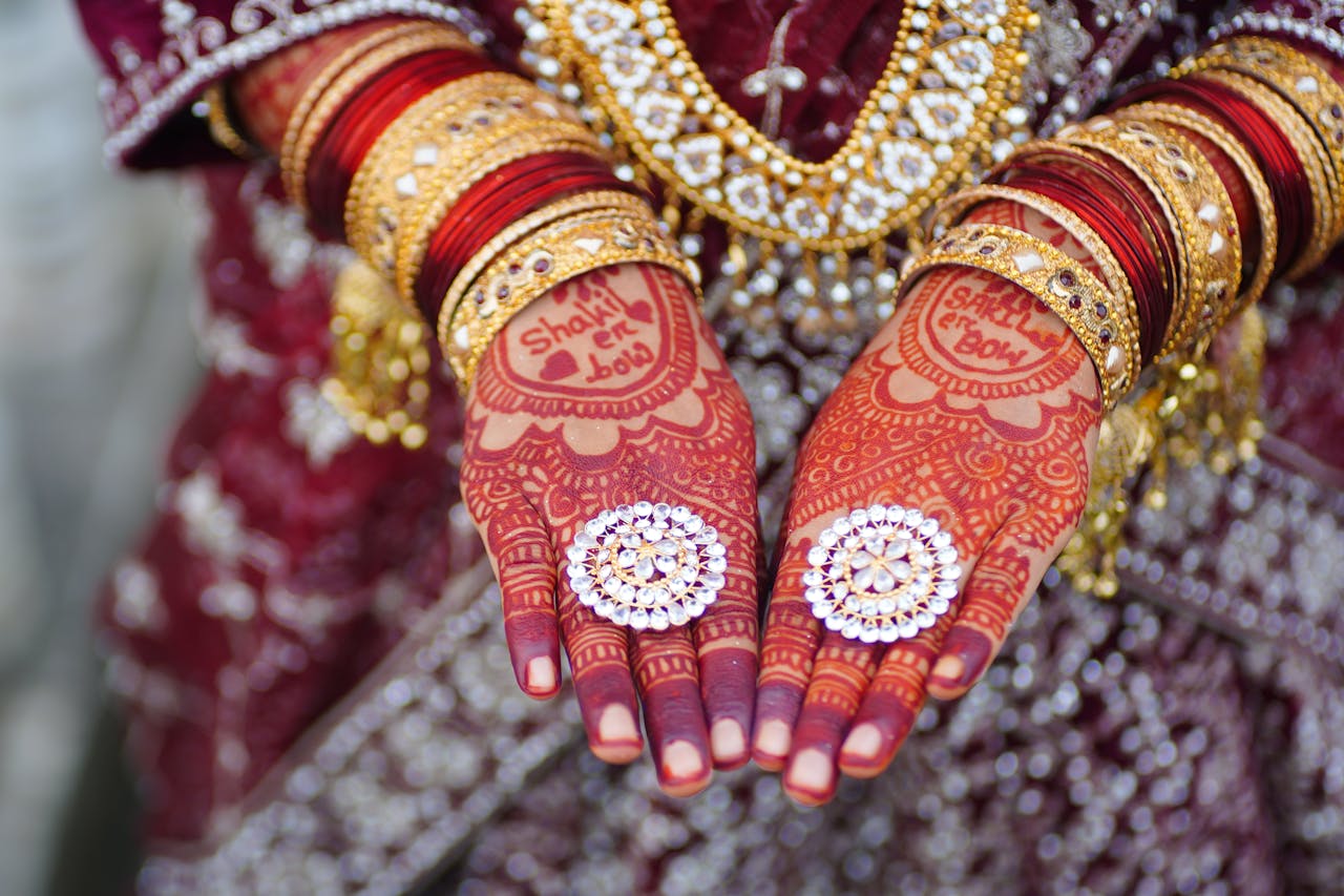 Beautifully adorned bridal hands with intricate henna, jewelry, and bangles, perfect for wedding themes.