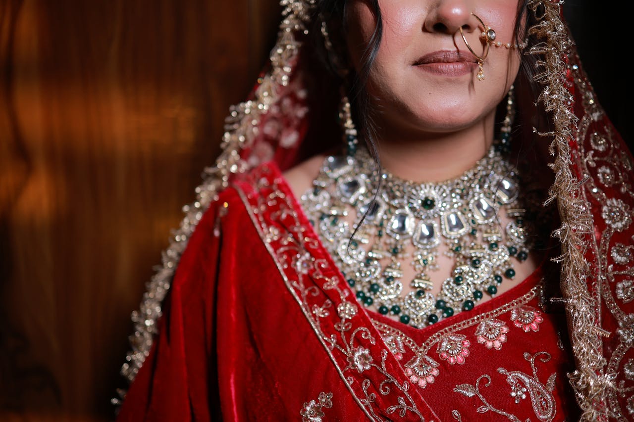 Close-up of a beautiful Indian bride in traditional red attire, adorned with intricate jewelry.
